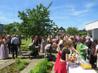 Bei strahlendem Sonnenschein beim Sektempfang in unserem Schulgarten